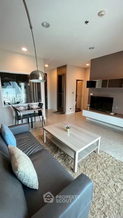 Modern living room with stylish furniture and open dining area in a contemporary apartment.