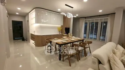 Modern open-layout kitchen and dining area with elegant lighting and sleek furniture.