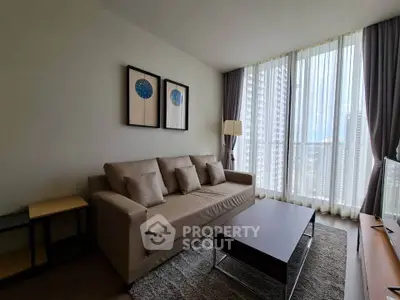 Modern living room with large windows and stylish decor in a high-rise apartment.