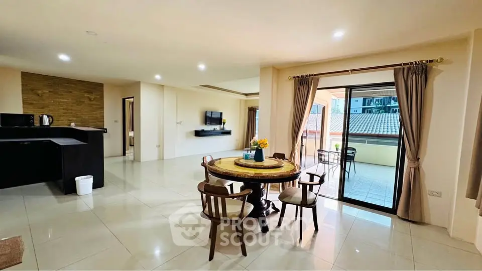 Spacious open-plan living room with dining area and balcony access in modern apartment.