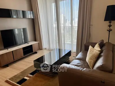 Modern living room with sleek furniture and city view from balcony.