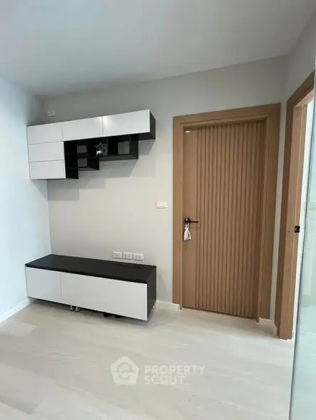 Modern minimalist interior with sleek storage units and wooden door, perfect for contemporary living.