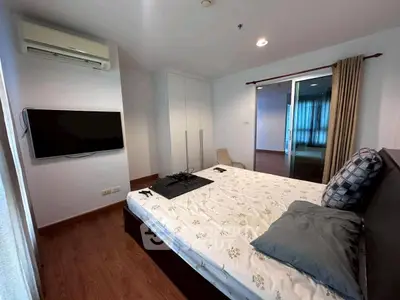 Modern bedroom with air conditioning and wall-mounted TV in stylish apartment