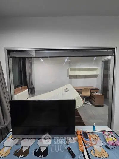 Modern bedroom with large window, TV, and minimalist furniture, ideal for urban living.