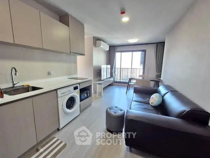 Modern living room with open kitchen and balcony view