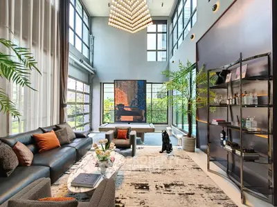 Luxurious modern living room with high ceilings and large windows, elegant decor and stylish furniture.