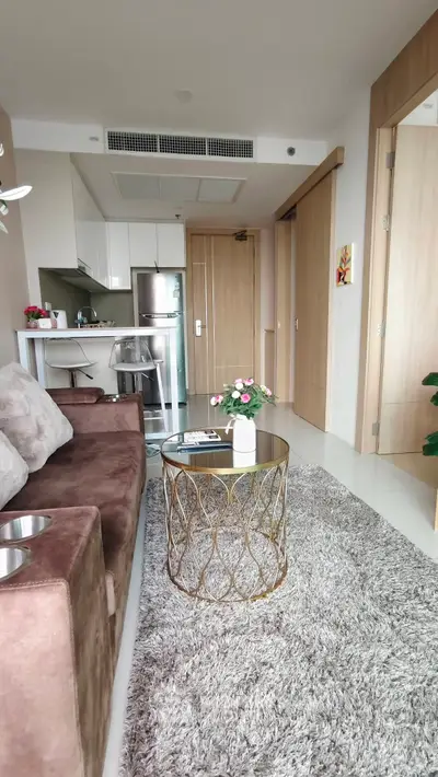 Modern living room with plush sofa, stylish coffee table, and sleek kitchen in open layout apartment.