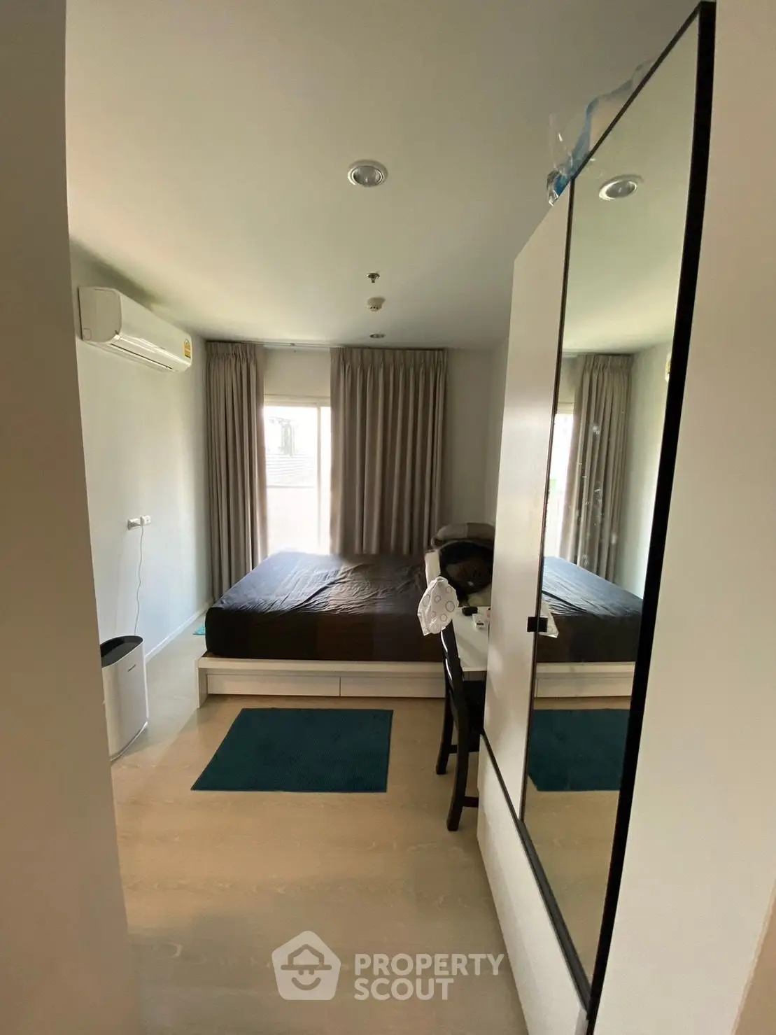 Cozy bedroom with modern furnishings and natural light, perfect for relaxation and comfort.