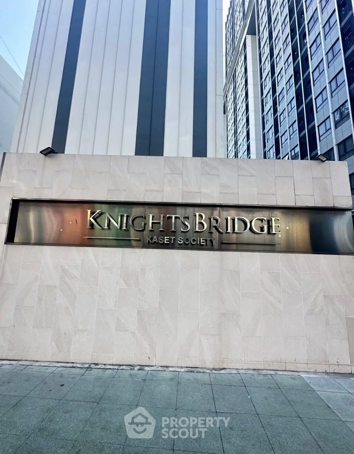 Modern high-rise building exterior with Knightsbridge Kaset Society signage.
