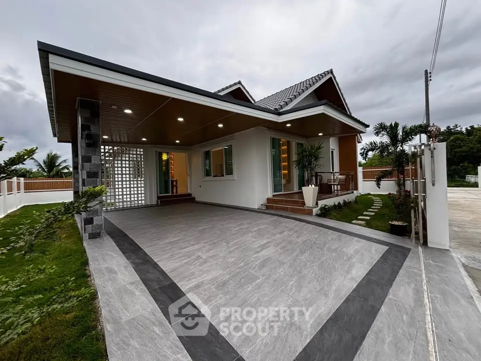Modern single-story house with spacious driveway and lush garden, perfect for family living.