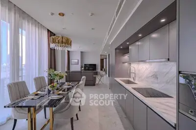 Luxurious open-plan kitchen and dining area with modern decor and elegant lighting