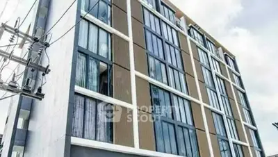 Modern apartment building exterior with large windows and contemporary design.