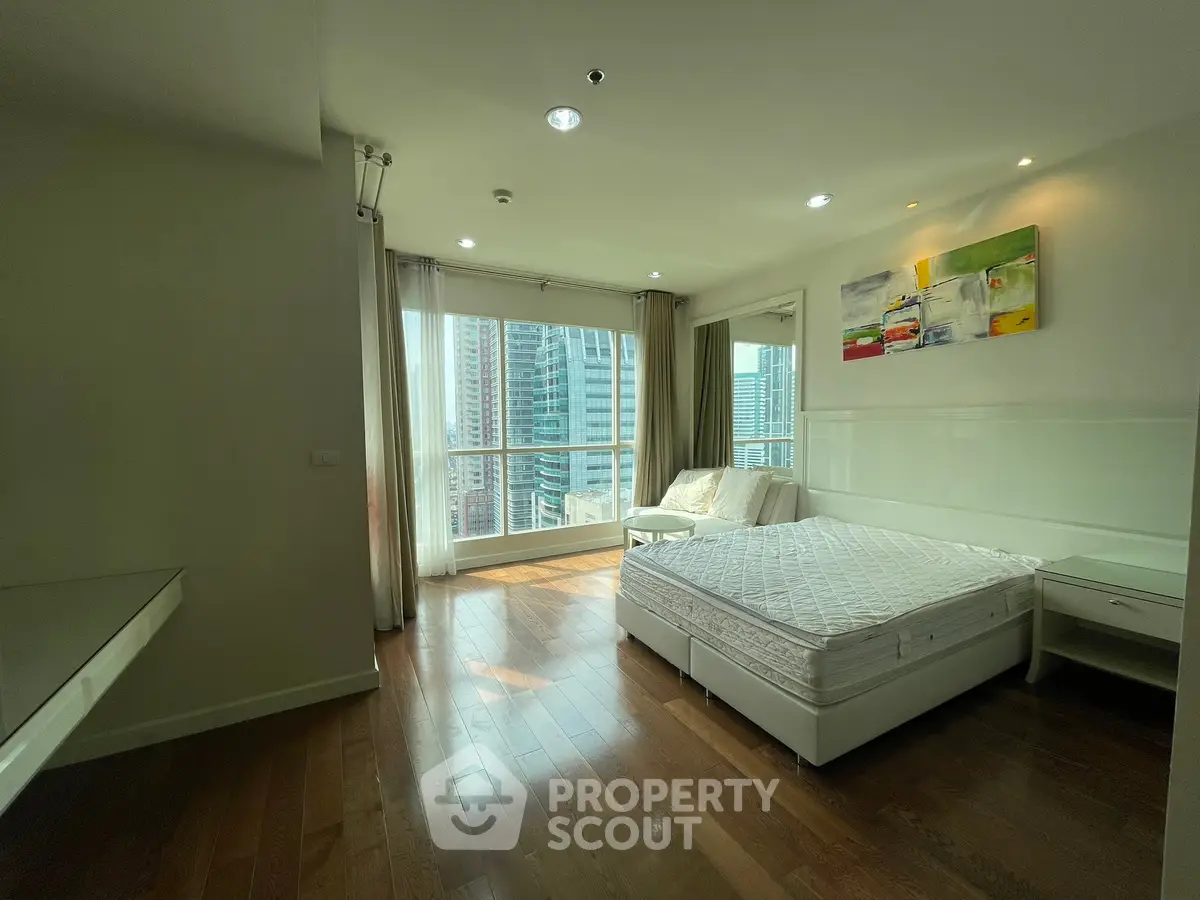 Spacious bedroom with city view and modern decor in high-rise apartment