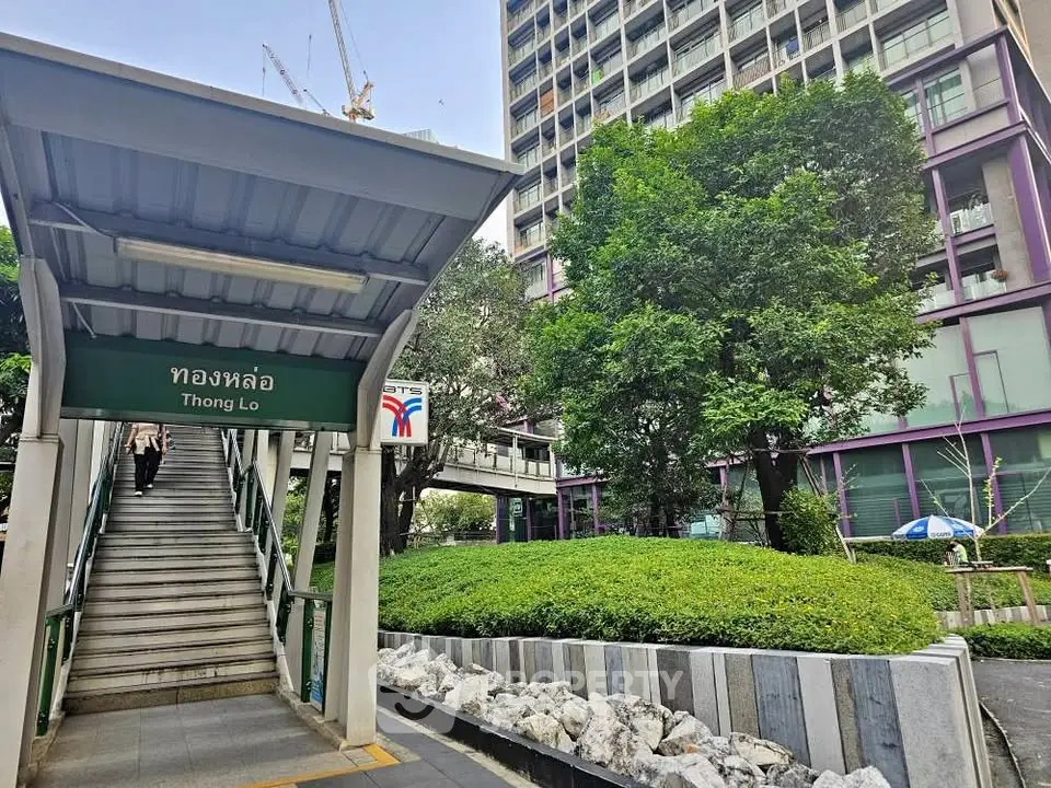 Modern urban building near Thong Lo BTS station with lush greenery and contemporary architecture.