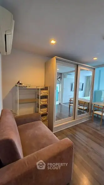 Cozy living room with mirrored wardrobe and modern furniture in a stylish apartment.