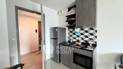 Modern kitchen with sleek cabinetry and geometric backsplash in a stylish apartment.