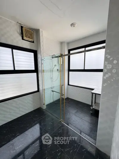 Modern bathroom with glass shower enclosure and large windows