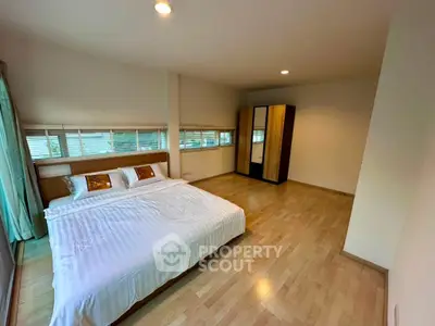 Spacious bedroom with wooden flooring and modern furnishings for a cozy living experience.