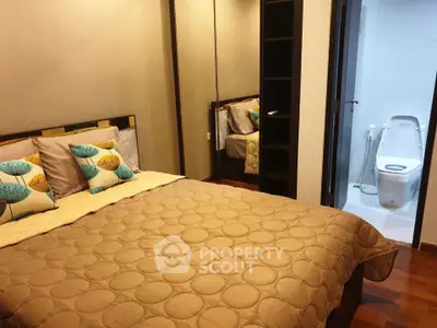 Cozy bedroom with modern decor and ensuite bathroom in stylish apartment.