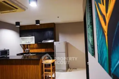 Modern kitchen with sleek black cabinets and stainless steel fridge