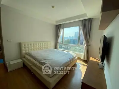 Spacious bedroom with city view, featuring a plush bed and modern decor, perfect for urban living.
