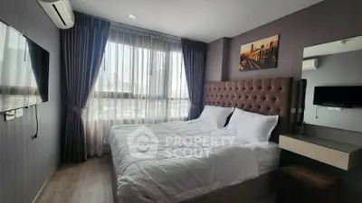 Modern bedroom with large window and stylish decor in a high-rise apartment.