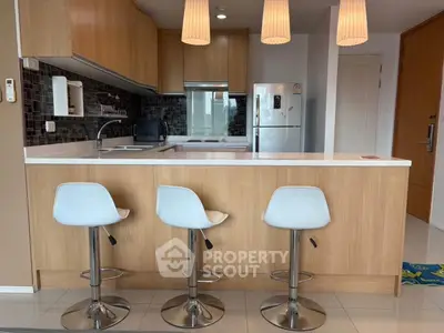 Modern kitchen with sleek wooden cabinets and stylish bar stools