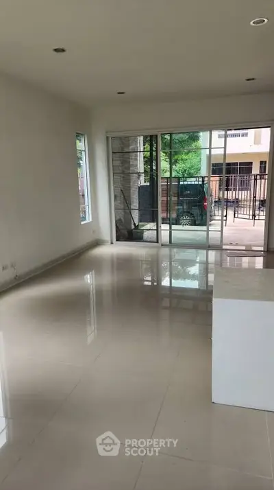 Spacious empty living room with large windows and glossy tiled floors