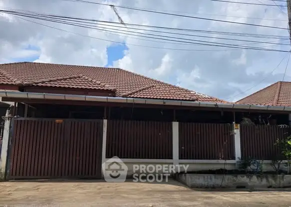 Charming single-story house with tiled roof and gated entrance, perfect for family living.