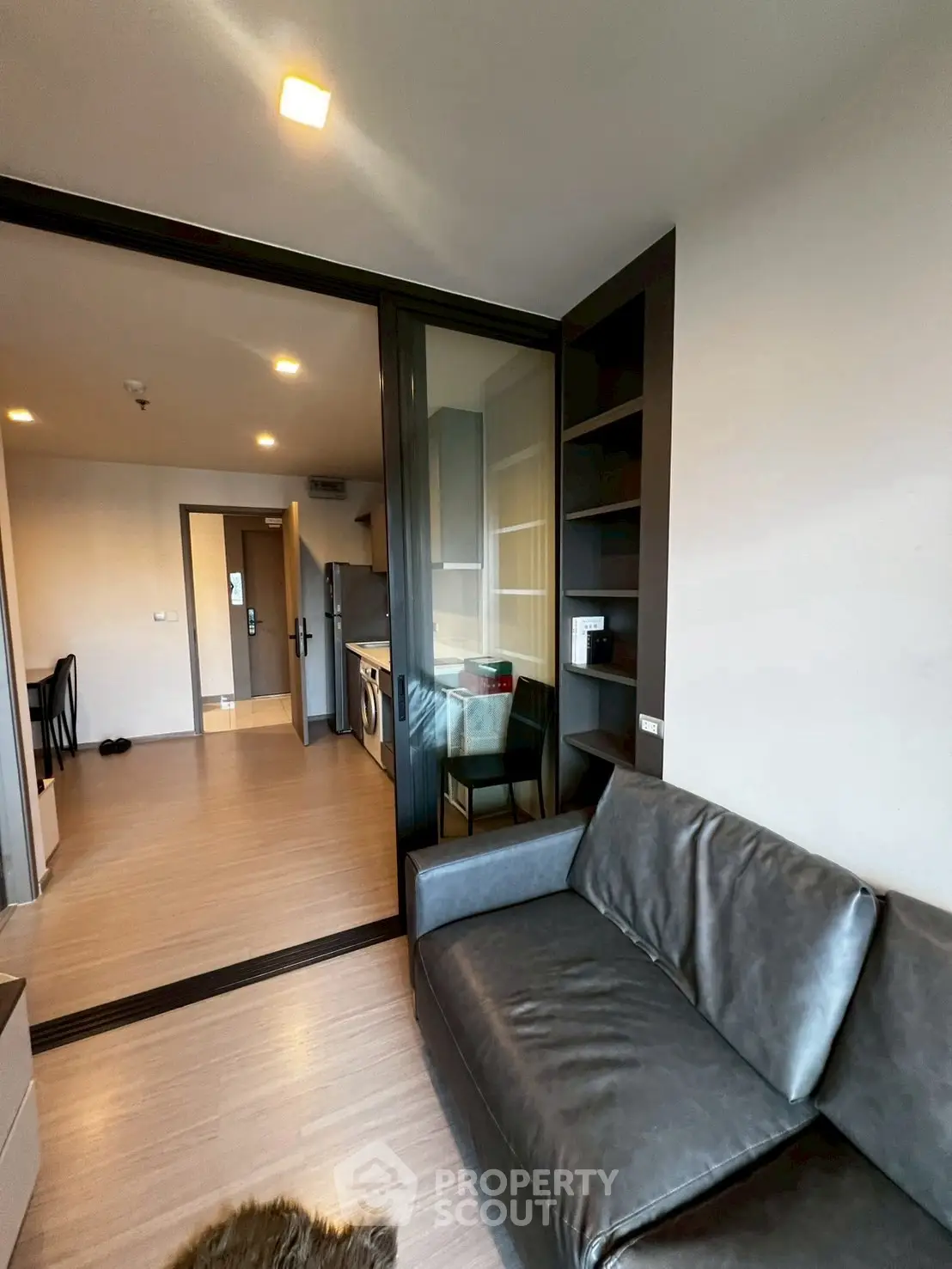 Modern living room with sleek leather sofa and open kitchen layout