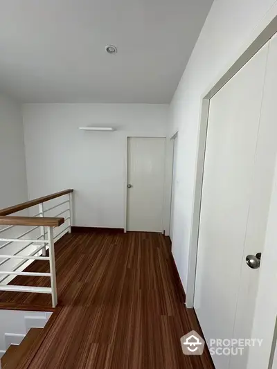 Modern hallway with wooden flooring and white doors in a contemporary home