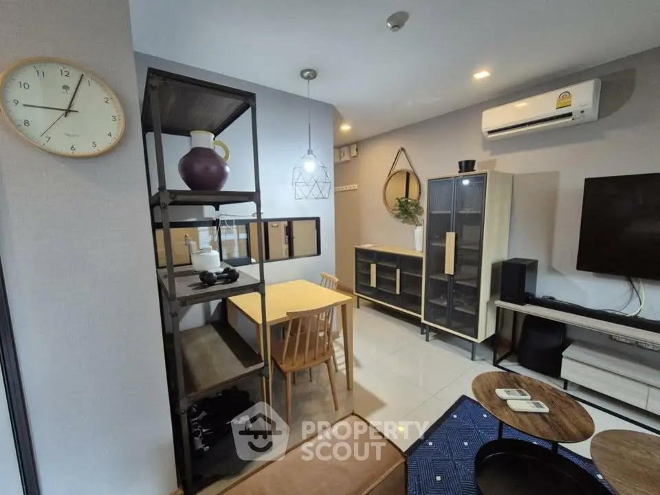 Modern living room with stylish furniture and air conditioning, featuring a cozy dining area and sleek shelving.