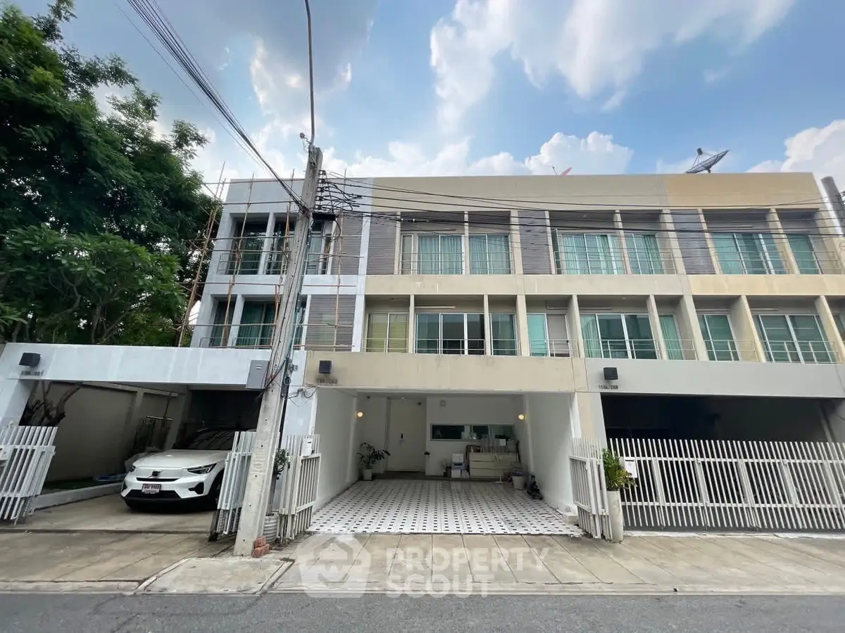 Modern townhouse exterior with carport and gated entrance
