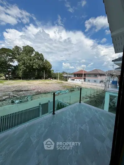 Spacious balcony with glass railing offering serene neighborhood views.