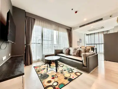 Spacious modern living room with large windows and stylish decor in a luxury apartment.
