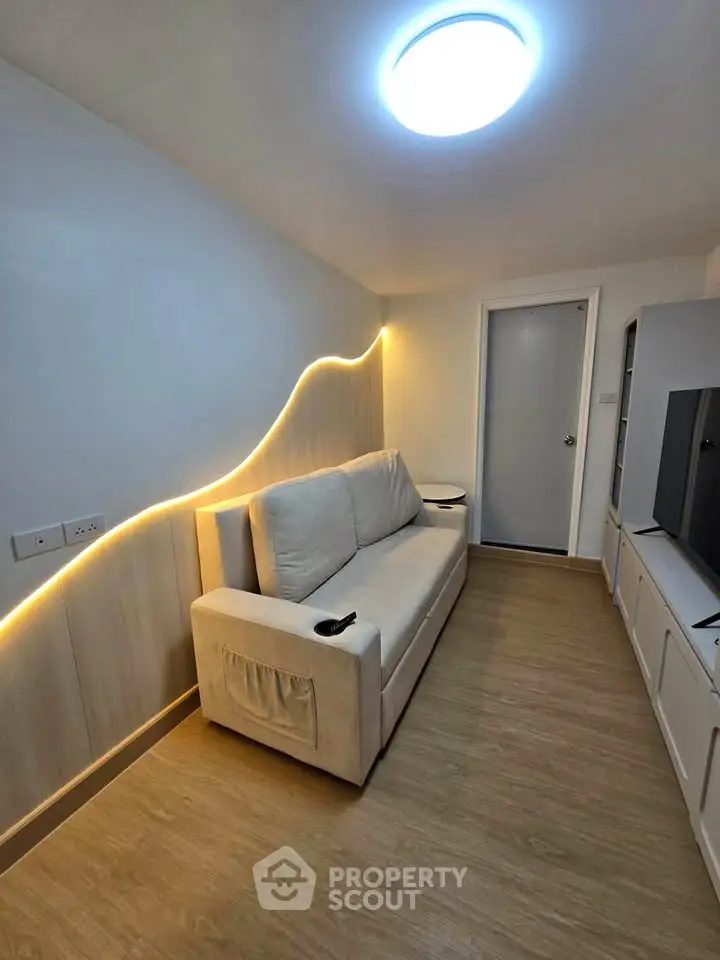 Modern living room with stylish lighting and cozy sofa in a compact space.