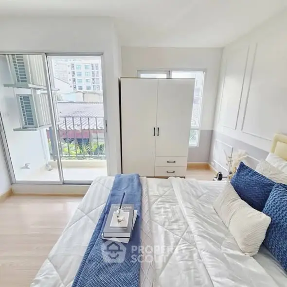 Bright and airy bedroom with modern decor and balcony access, perfect for urban living.