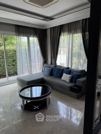 Elegant living room with large windows and stylish gray sofa