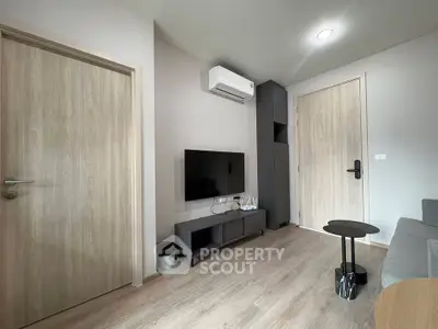 Modern living room with sleek design, featuring a wall-mounted TV, air conditioning, and stylish furniture.