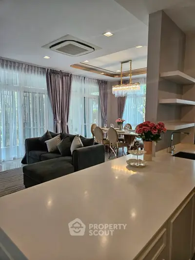 Luxurious open-plan living and dining area with elegant decor and large windows for natural light.
