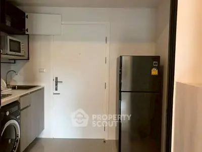 Modern compact kitchen with stainless steel appliances and washing machine