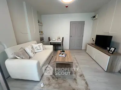 Modern living room with cozy sofa, stylish decor, and entertainment center in a contemporary apartment.