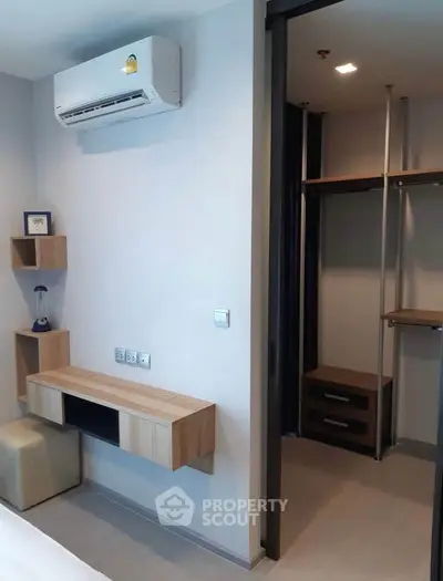 Modern bedroom with built-in closet and air conditioning in a stylish apartment.