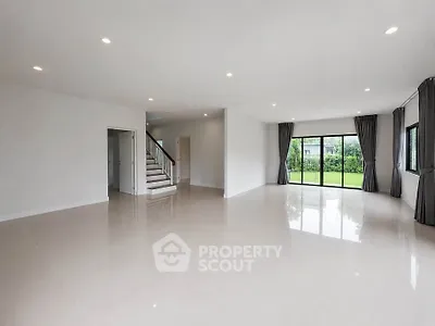Spacious modern living room with large windows and garden view