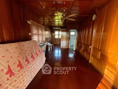 Spacious wooden interior with ceiling fan and natural light, ideal for cozy living space.