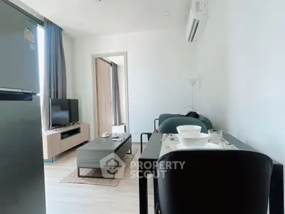 Modern living room with sleek furniture and dining area in a stylish apartment.