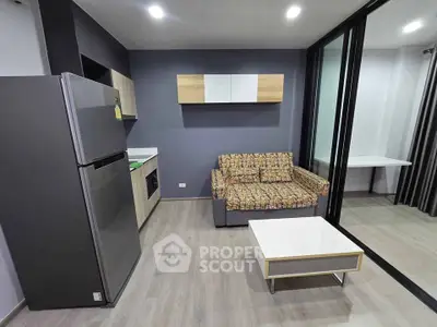Modern living room with stylish sofa, sleek kitchen, and contemporary decor in open layout apartment.