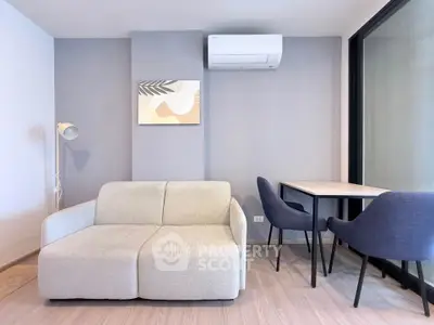 Modern living room with stylish sofa, air conditioning, and cozy dining area in a contemporary apartment.