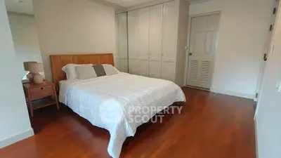 Spacious bedroom with wooden flooring and built-in wardrobe
