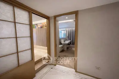 Elegant interior hallway leading to a modern living space with stylish decor.